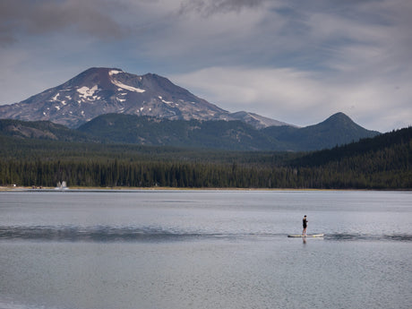woman paddle boarding in mountain lake