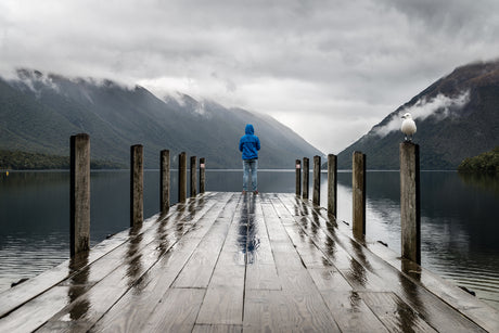 Person standing at the end of a pier wearing hdry jacket and gear